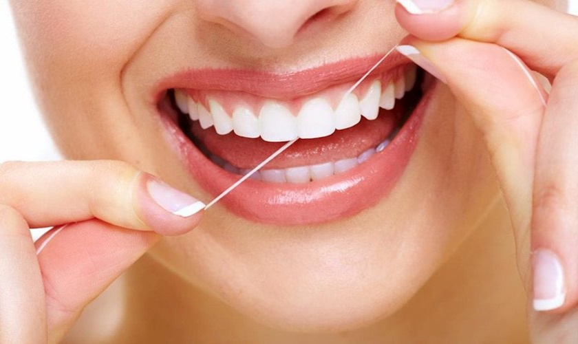 Sau khi trồng răng nên sử dụng chỉ nha khoa để vệ sinh tránh tác động mạnh khiến máu bong ra